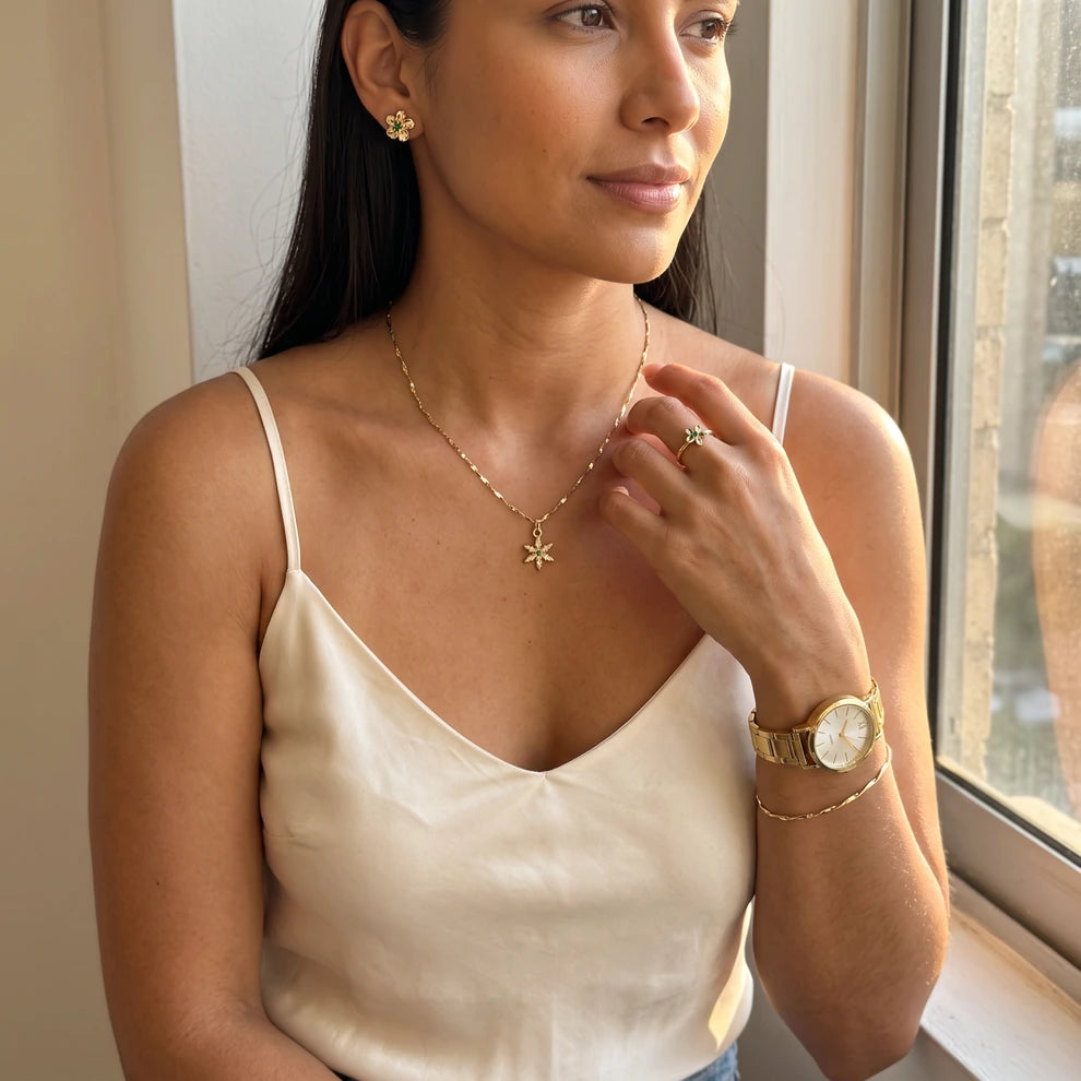 Modelo luciendo el Conjunto Florencia: cadena con dije estrella, topos, anillo, reloj y pulsera