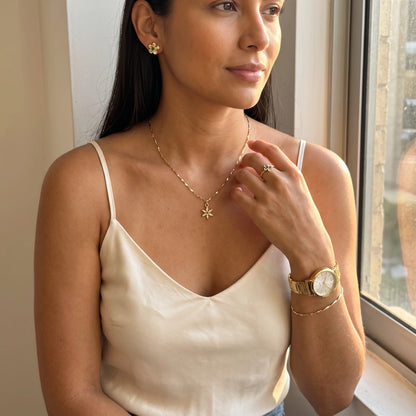 Modelo luciendo el Conjunto Florencia: cadena con dije estrella, topos, anillo, reloj y pulsera